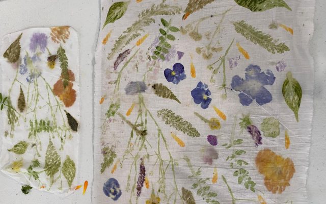 A photograph of two rectangular fabric prints of wildflowers laid out on a white table.