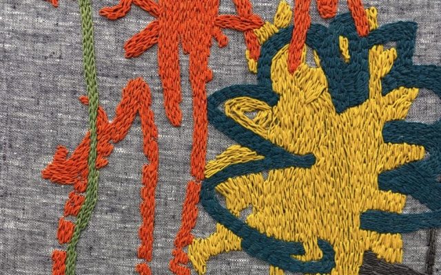 A close-up image of Amalia Pica’s embroidery piece, ‘Keepsake #15’ (2025). Vibrant, freeform lines mostly in red and yellow are stitched onto a grey, linen background.