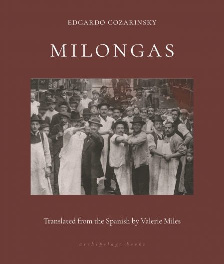 The book cover for ‘Milongas’ by Edgardo Cozarinsky, translated from Spanish by Valerie Miles. The cover is burgundy and displays a black and white photograph in the middle. In the image, a crowd of men stand in the street looking at the camera. Those at the front stand in a dancing hold, with clasped hands stretched out towards the camera. White text displays the title, author’s name and translator.